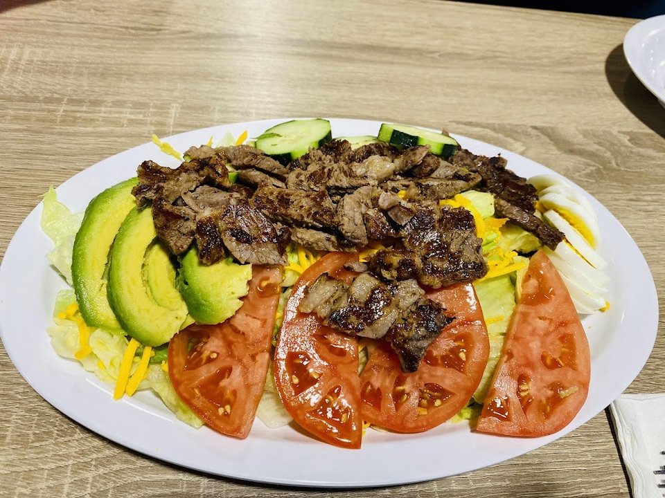 Steak and eggs served on a diner-style plate.